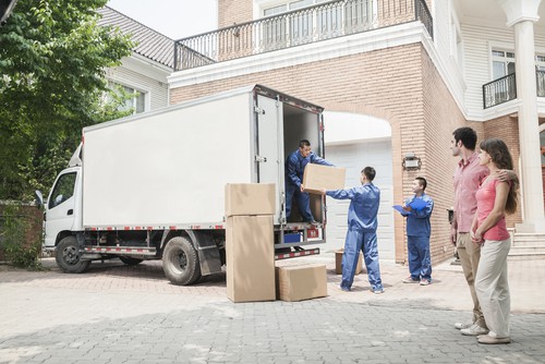 young couple watching movers load truck.