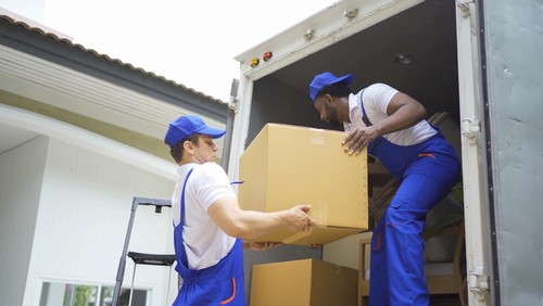 movers loading boxes into truck.