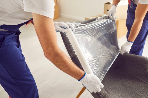 movers wrapping furniture.