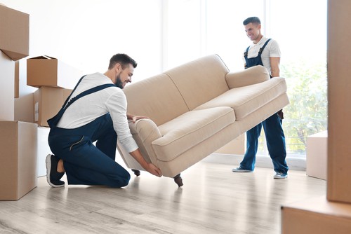 movers placing a couch on the ground.